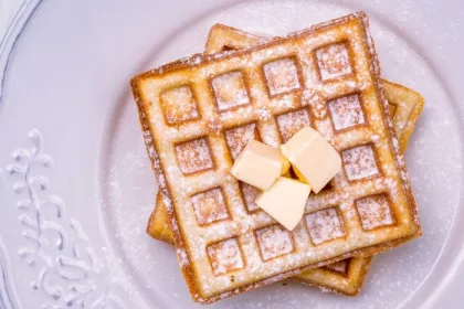 Prepared frozen waffles; flat lay on a white ceramic plate with butter
